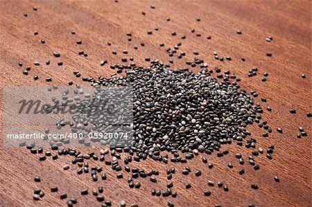 Chia seeds on wooden background, close up.