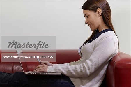 E-commerce with happy woman using pc and credit card while shopping on the web at home. Side view, copy space