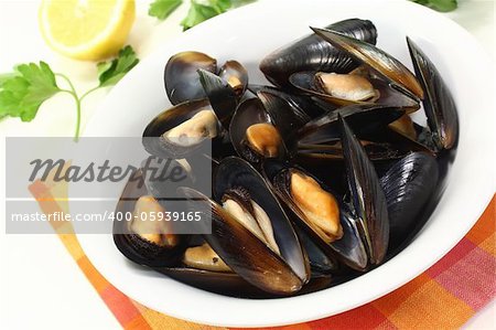 fresh cooked mussels in a white bowl with napkin