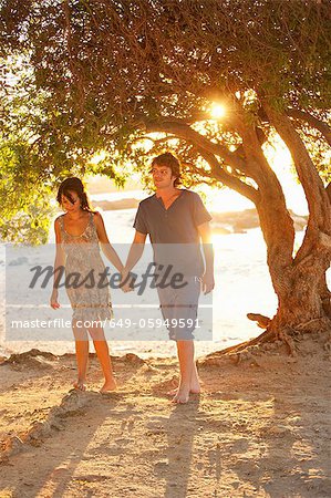 Couple walking barefoot in park