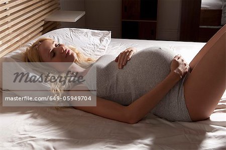 Schwangere Frau schlafend im Bett