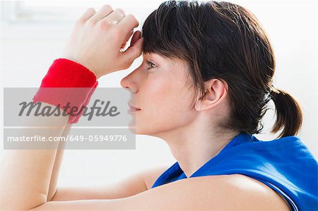 Woman resting forehead in hands