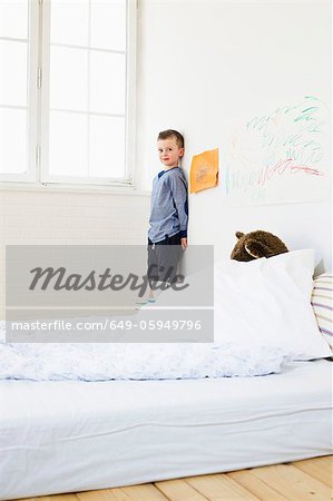 Boy with drawings on bedroom wall