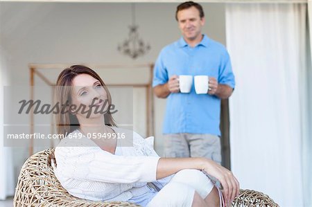 Man bringing girlfriend coffee on porch