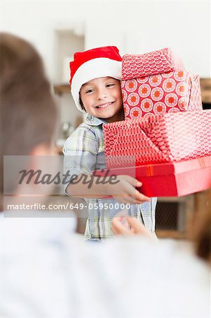 Boy in Santa hat with Christmas gifts