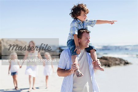 Father carrying son on shoulders