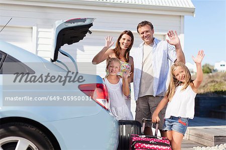 Family loading up car trunk for vacation