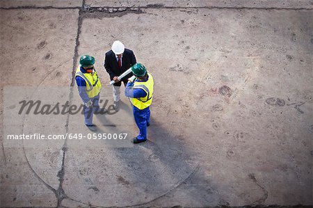 Workers with blueprints on dry dock Workers with blueprints on dry dock