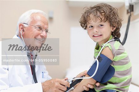 Doctor examining boy in office