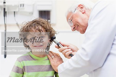 Doctor examining boy in office