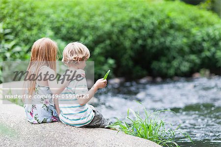 Children sitting on rock together