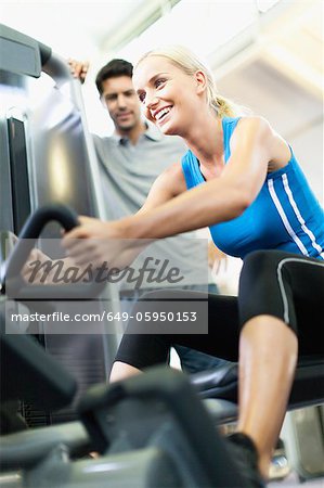Femme travaillant avec formateur dans la salle de gym