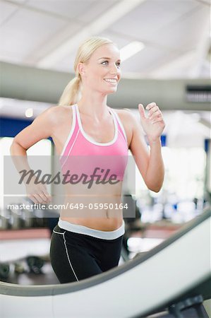 Woman using exercise machine in gym