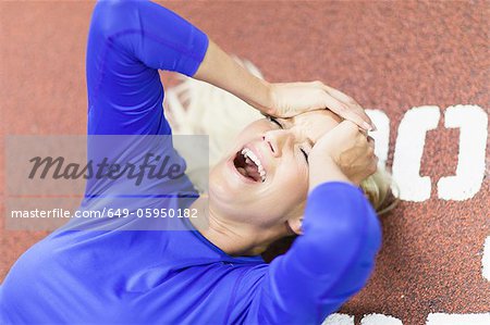 Femme crier sur une piste intérieure dans une salle de sport