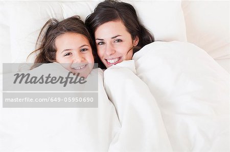 Mother and daughter relaxing in bed