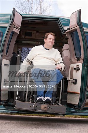 Man with spinal cord injury in a wheelchair coming out from a wheelchair accessible van