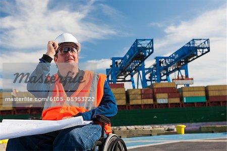 Transportation Ingenieur in einem Rollstuhl studieren Pläne bei Versand port