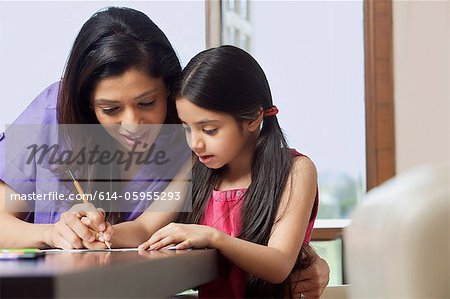 Mother teaching her daughter to write