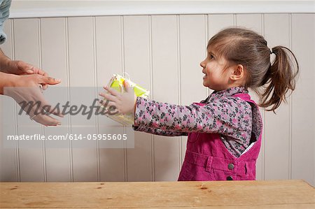 Kleine Mädchen, die ein Geschenk für Erwachsene