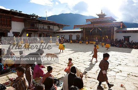 Danse masquée dans la cour principale de le Gangte Goemba tandis que la population locale et les touristes regardent pendant le Gangtey Tsechu, gaudart, vallée de Phobjikha, Bhoutan, Asie