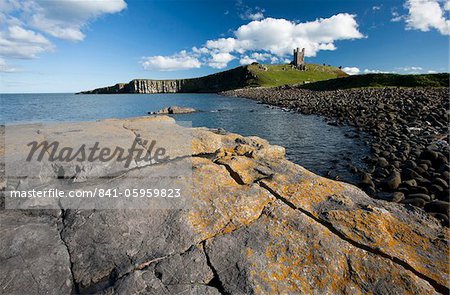 Les ruines du château de Dunstanburgh dans la distance de Greymare Rock sur l'après-midi, Embleton Bay, Northumberland, Angleterre, Europe de l'été ensoleillé
