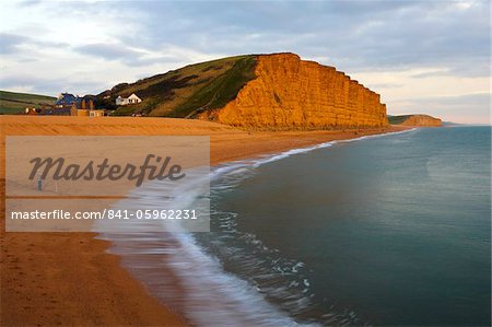 Un pêcheur solitaire se dresse sur la plage de West Bay, Côte Jurassique, patrimoine mondial de l'UNESCO, Dorset, Angleterre, Royaume-Uni, Europe