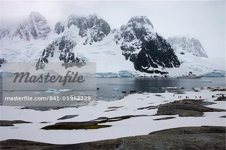 Touristes se promenant dans une colonie de pingouins à Pleneau Island, péninsule Antarctique, l'Antarctique, les régions polaires