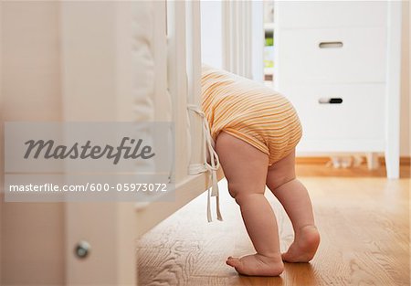 Baby Girl Climbing into Crib