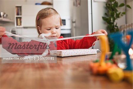 Petite fille assise à Table, déballer les cadeaux