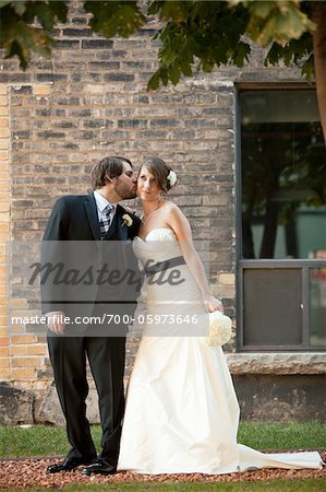 Bräutigam küssen Braut auf Wange