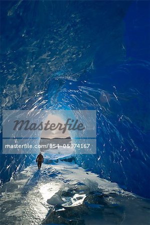 Homme marche à l'intérieur d'une grotte de glace d'iceberg gelé en hiver, sud-est de l'Alaska, Juneau, lac Mendenhall