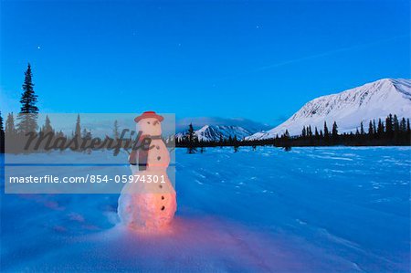 COMPOSITE, debout de bonhomme de neige dans un champ à la nuit tombante, hiver, large col, Parcs autoroute, centre-sud de l'Alaska