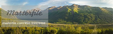 Composite panorama of evening sun on Polar Bear and Eagle Peaks and Hurdygurdy Mountain overlooking Eagle River Valley in Chugach State Park in Southcentral Alaska. Summer.