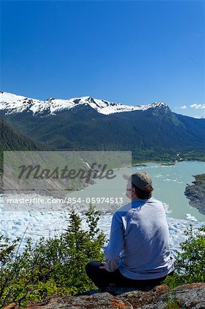 A male hiker looking down onto Mendenhall Glacier and Mendenhall Lake from West Glacier Trail, Juneau, Southeast Alaska, Summer