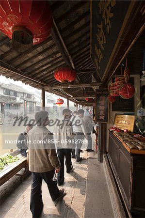 Souvenirläden auf dem überdachten Gang durch den Kanal, Altstadt von Xitang, Zhejiang, China