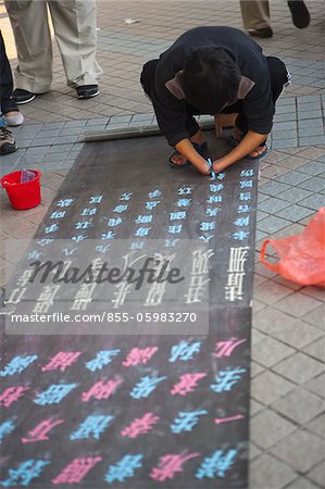 A handicapped man writing for begging on the footbridge, Central, Hong Kong