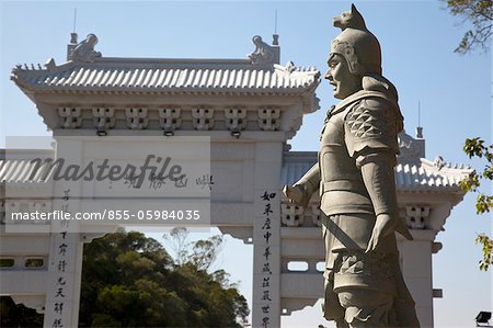 Gateway an der Zufahrt zur Po-Lin-Kloster mit einer Statue im Vordergrund, Lantau Island, Hong Kong