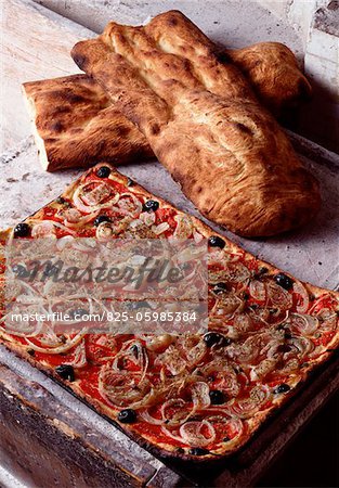 Spanish Coca de Recapte pizza with olive oil, tomatoes, black olives and onions