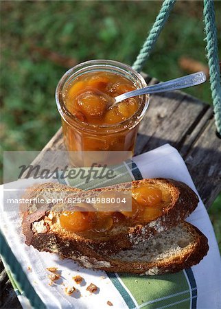 Jar of plum jam and plum jam on slices of bread