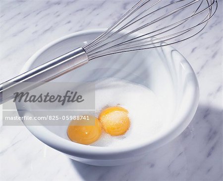 Sugar and eggs in bowl with whisk