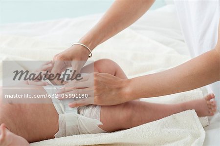 Baby having diaper changed, cropped