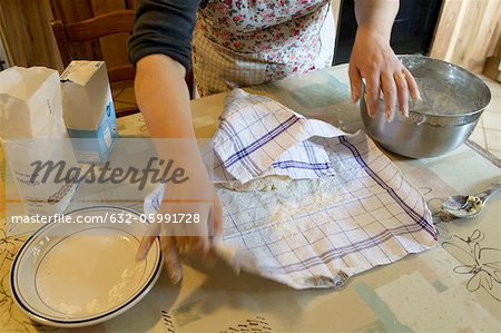 Femme couvrant la pâte avec une serviette, recadrée