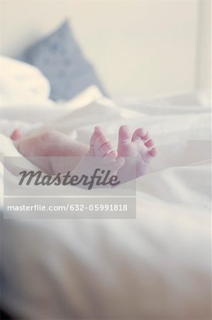 Baby's bare feet on bed