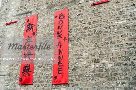 Couplets in with Chinese and Western scripts hanging on brick wall