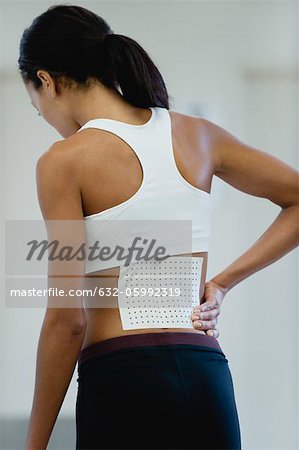 Woman with bandage on lower back, rear view