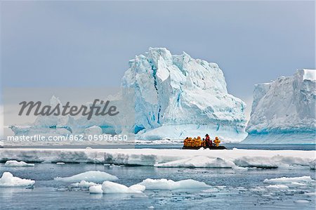 Visitors to the Antarctic Peninsula admire icebergs and ice flows in the Yalour Sound off Joinville Island from a Zodiac inflatable boat.