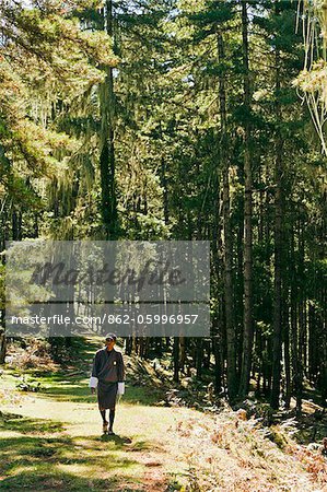 A young Bhutanese man walking in the forest in Phobjika Valley.