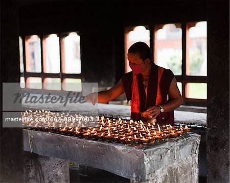 Lighting butter lamps at the beautiful 7th century Jampey Lhakhang, near Jakar in the Chokhor Valley.
