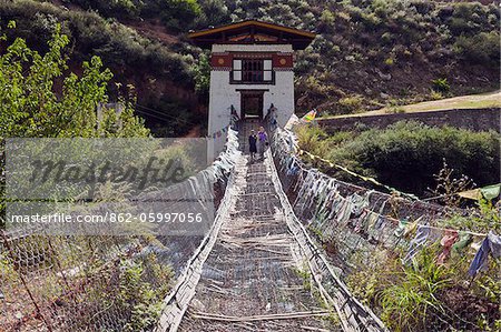 A tourist gingerly walking over the swaying iron suspension bridge at Tamchhog Lhakhang, a monastery built in the 14th century by Dewa Zangpo..