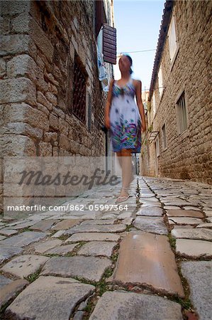 Croatia, Trogir, Central Europe. Young woman walking in the historical centre.